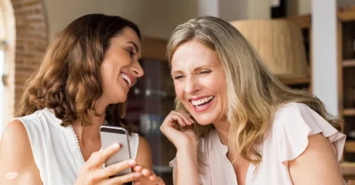 2 Frauen, die miteinander lachen. Lachfalten und Zornesfalten werden häufig mit Botox-Anwendungen kaschiert