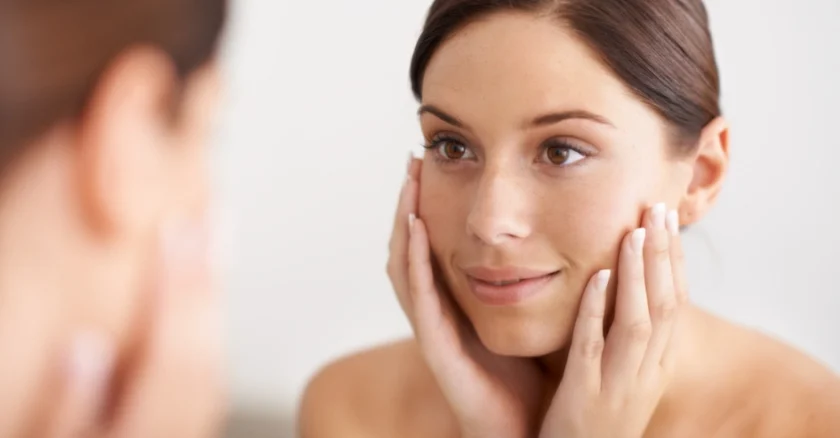 attraktive Frau betrachtet ihr Hautbild, schöne Haut basierend auf Inositol Tabletten Hautpflege